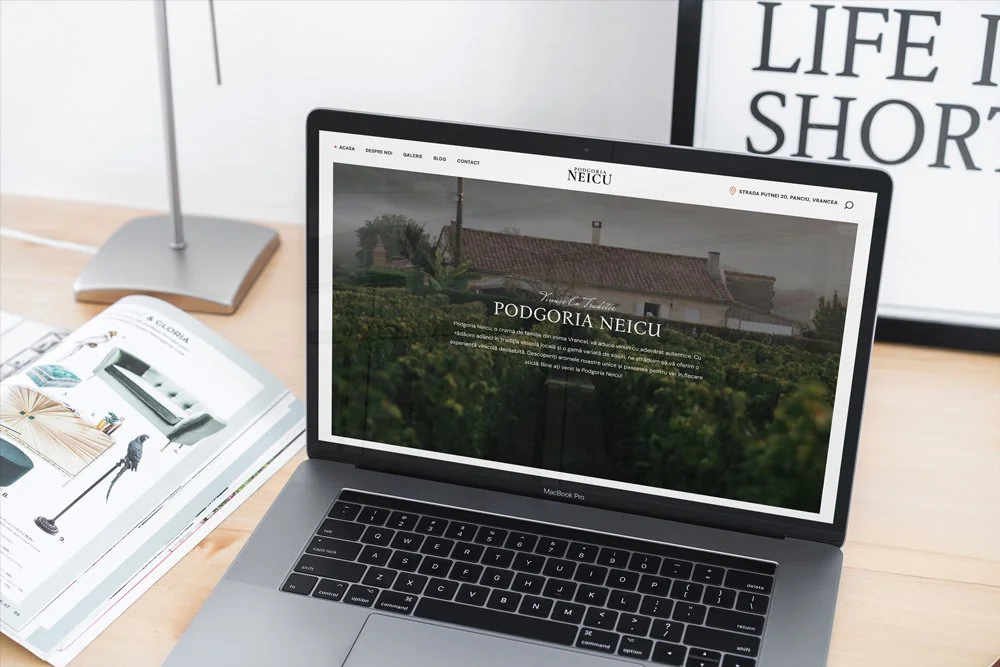 Laptop cu site-ul Podgoria Neicu și prezentarea vinului și a strugurilor