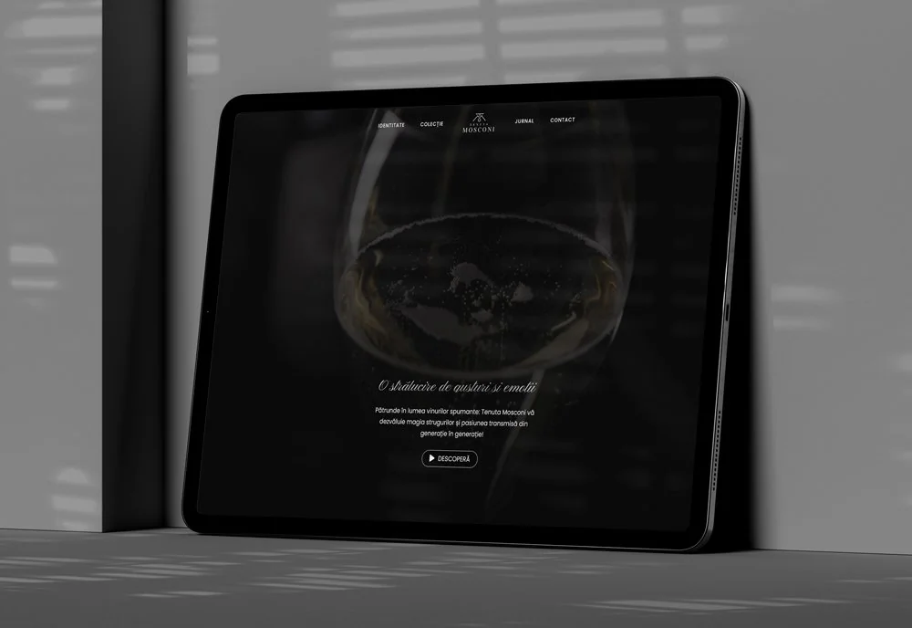 Tabletă într-un decor întunecat, cu site-ul Tenuta Mosconi pe ecran